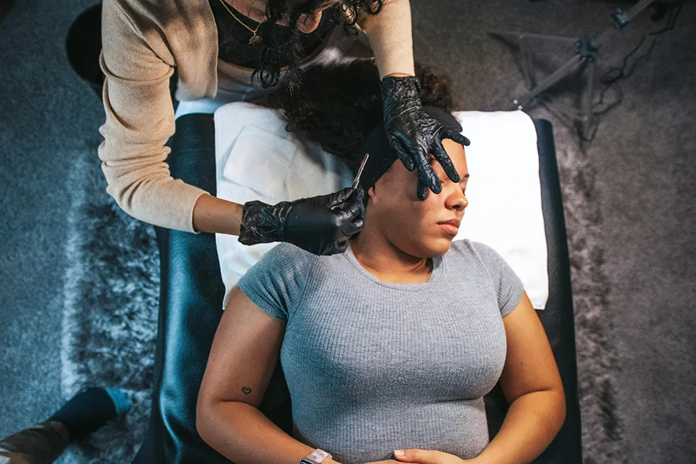 A woman laying on a chair receiving a dermaplaning services