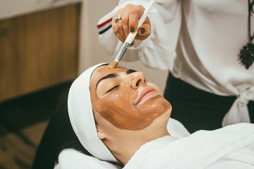 A woman getting a skin care mud facial